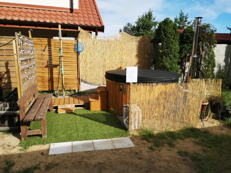 Drewniana balia (jacuzzi) w ogrodzie przy domkach